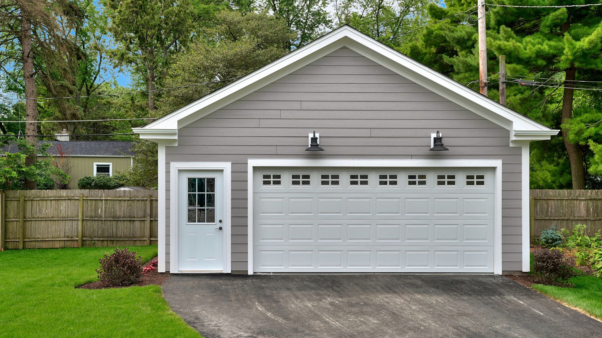 A gray garage with a white door and windows