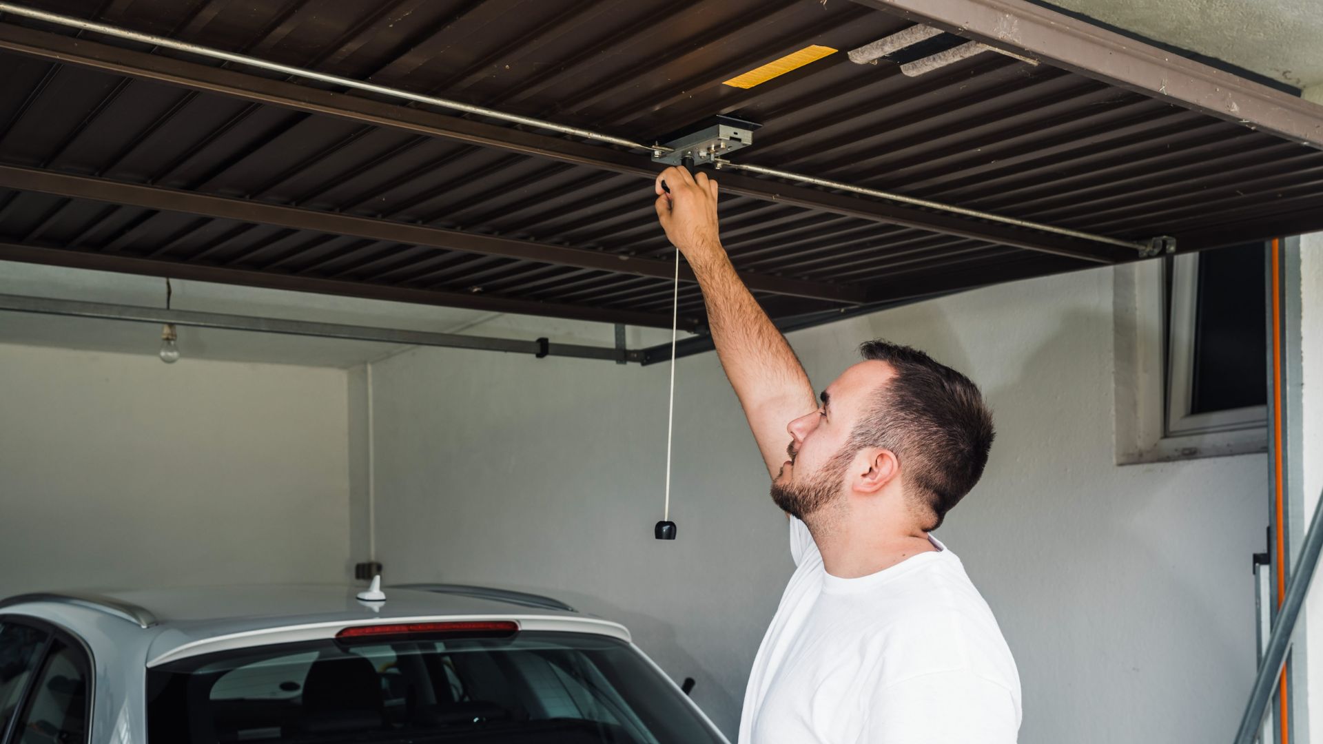 A man is fixing a garage ceiling light