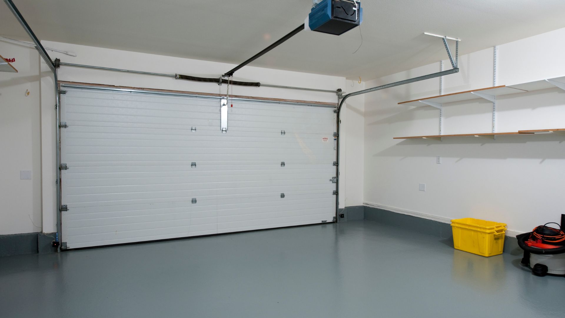 A white garage with a yellow trash can